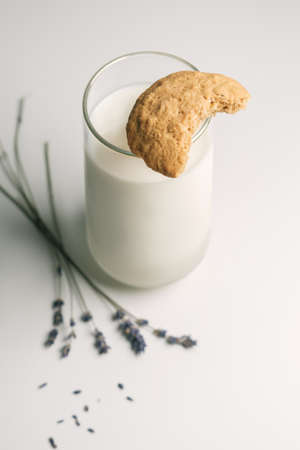 Bitten off cookie on glass of milkの写真素材