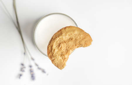 Bitten off cookie on glass of milkの写真素材