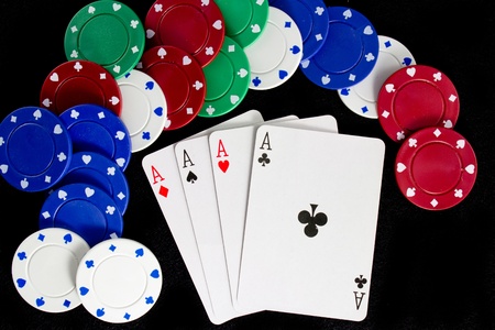 Four Aces with Poker Chips Against Black Background