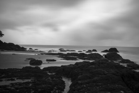 An black and white Long exposure of a stretch of beach on a rainy day at the beach of Etty Bay near...