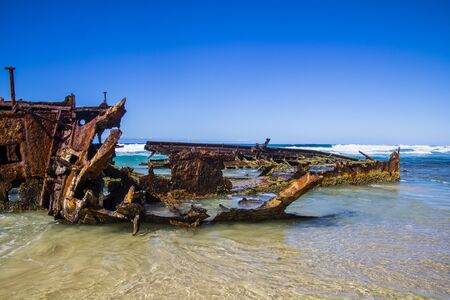 Photograph of the shipwreck of the SS Maheno on Fraser Island with a cloudless sky in the background. Fraser Island is located off Queensland in eastern Australiaの写真素材