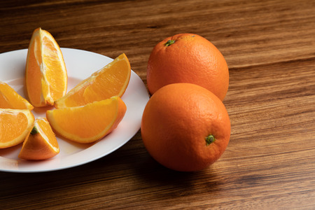 Plate of oranges on a wooden tableの写真素材