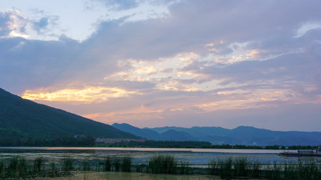Sunset at the lake with mountain background in the evening time.の写真素材