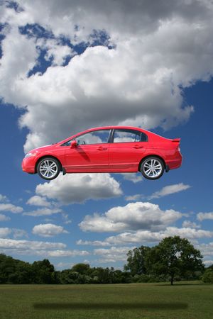 bright red compact car enjoying beautiful day in parkの写真素材