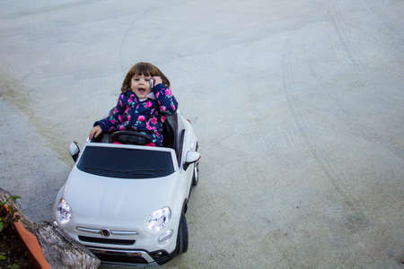 adorable little girl simulating a car accident and calling for helpの写真素材