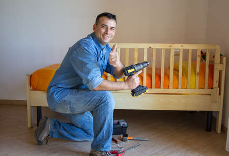 handyman dad after mounting the guard rail to the bedの写真素材