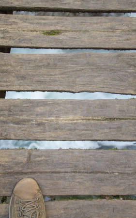 Image of a man's boot during a mountain hike as he crosses a wooden bridge along the Scalelle path in Caramanico Terme Abruzzo Italy. Vertical bannerの写真素材