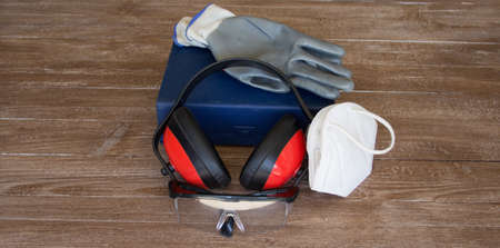 Image of gloves, goggles, headphones, face mask and a first aid box. Representation of accidents occurring at workの写真素材