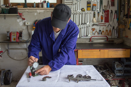 Picture of a mechanic in his workshop taking measurements with a thickness gauge and micrometer....