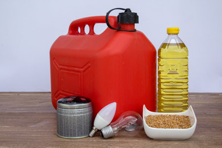 Image of a petrol can, light bulbs, a can of gas, bottle of seed and wheat oil. Reference to the increasing cost of these productsの写真素材
