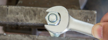 Image of a mechanic's hand tightening a bolt with a wrench. DIY work in the workshopの写真素材