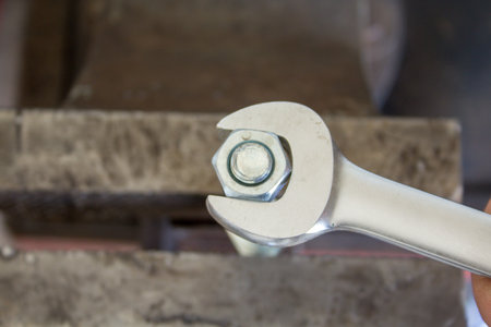 Image of a mechanic's hand tightening a bolt with a wrench. DIY work in the workshopの写真素材