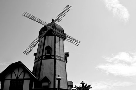 Black and white image of old windmill under cloudy skyの写真素材