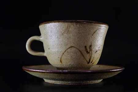 Tea cup or antique ceramic coffee cup  Beautiful and charming in the old, rough texture is a rare object for collectors, black background isolated.の写真素材