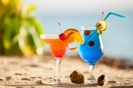 Colorful cocktails standing in the sandの写真素材