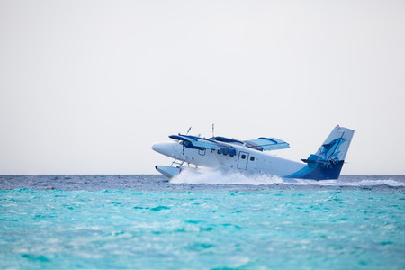 Seaplane is landing on water near an islandの写真素材
