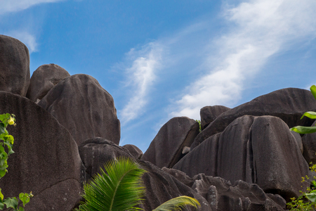 Blue sky with some clouds and big stones in frontの写真素材