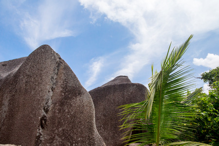 Blue sky with some clouds and big stones in frontの写真素材