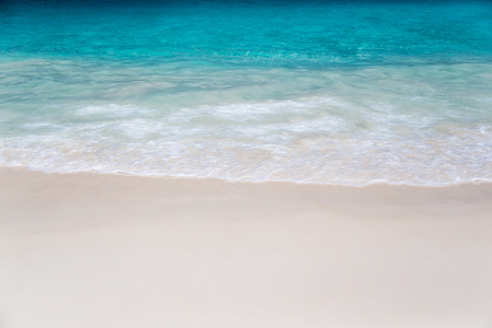 The beach with white sand and turquoise water with wavesの写真素材