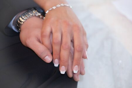 Bride and groom hold their hands romanticallyの写真素材