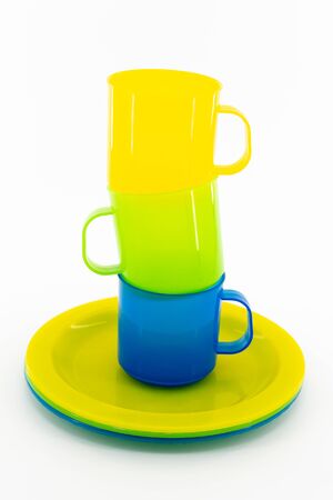 The three colored mugs and three colored saucers on a white backgroundの写真素材