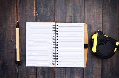 Note pen and Measuring Tape on wood backgrondの写真素材