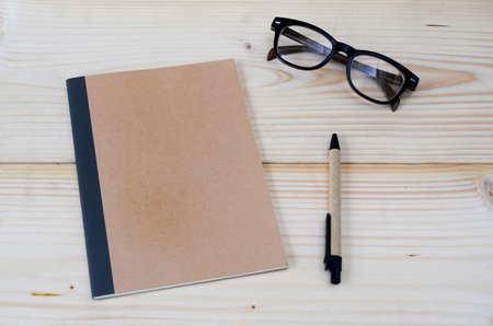 Note,pen and glasses on wood backgroundの写真素材