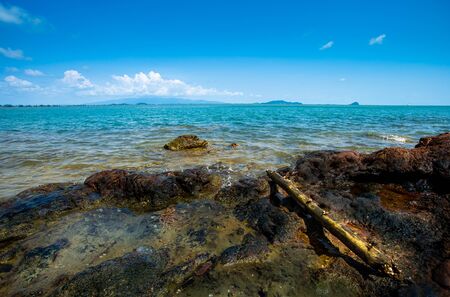 Rocks at sea with blue sky and cloudsの写真素材