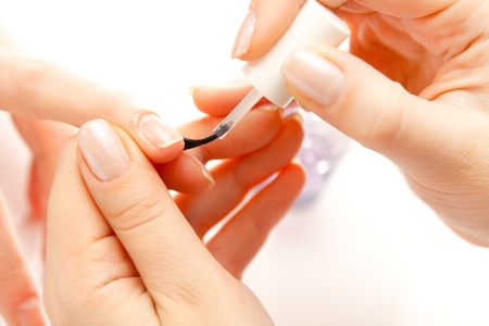 Manicurist applying nail polish on female fingersの写真素材