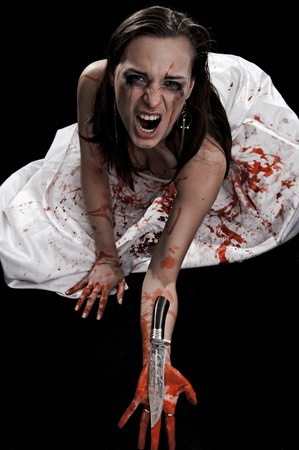yelling woman with knife in blood on black backgroundの写真素材