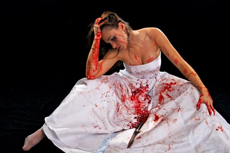 sad woman with knife isolated on black backgroundの写真素材