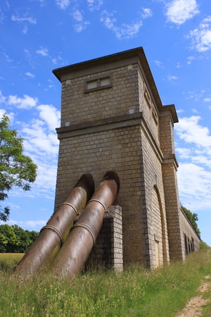 a medieval old pipeline in a field on blue sky backgroundの写真素材