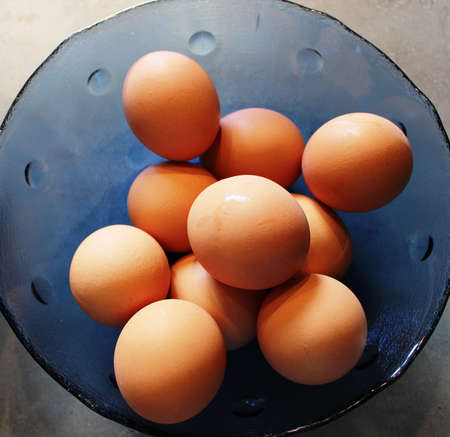 brown eggs in a blue glass bowl