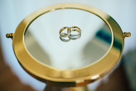 Beautifull wedding rings on the mirrow in sunny dayの写真素材