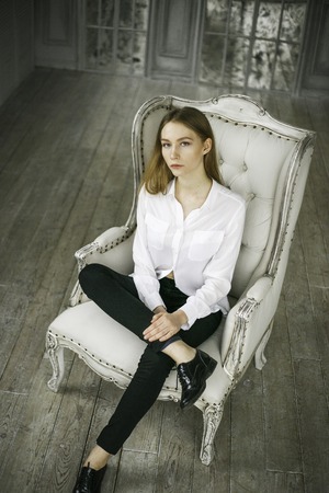beautiful blond young woman in a white dress relax at homeの写真素材