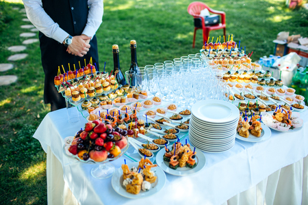 table set for wedding or another catered event dinner outdoor with waiterの写真素材
