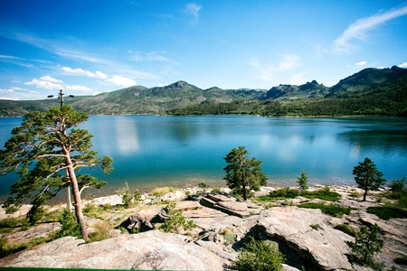 Blue lake idill under cloudline sky with rocks and stonesの写真素材
