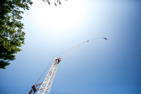 Bungee jumping man with tower and skyの写真素材