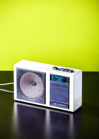 Old retro radio on table on green wall backgroundの写真素材