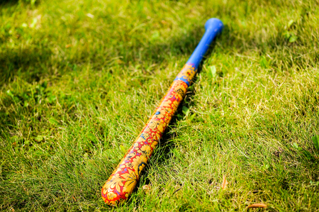 Handmade wooden bat khokhloma on the green grassの写真素材