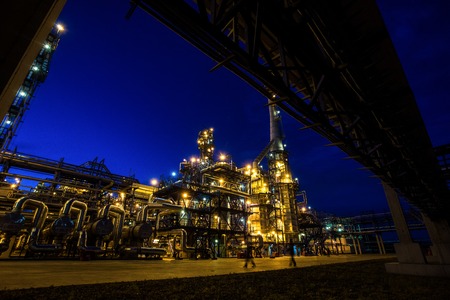 Pipes and buildings of big modern factory at the nightの写真素材