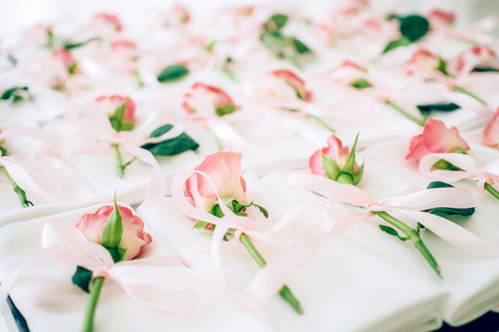 The red rose on the white table with a satin ribbon - as gift for guests - as beautiful backgriundの写真素材