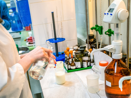 woman hands mixing folrmula in the laboratory with bottles of chemicals on backgroundの写真素材