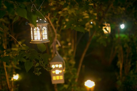 Candlestick house on the tree in garden at nigth with blur lights, romantic decor for date, nobodyの写真素材