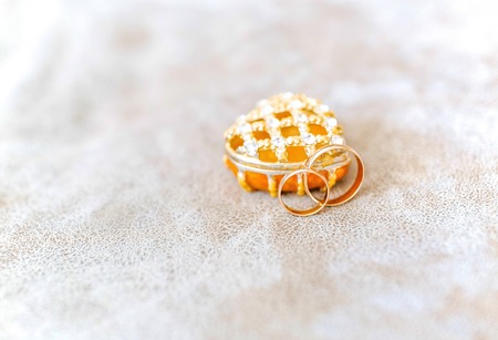 Photo of golden wedding rings before ceremony with box like heartの写真素材
