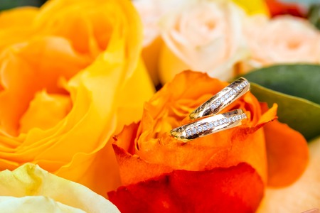 bouquet of flowers and wedding rings as backgroundの写真素材