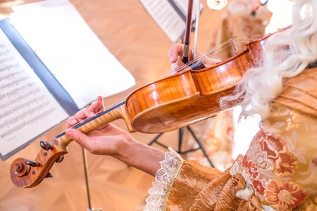 woman playing the violin in costume. close-up photoの写真素材