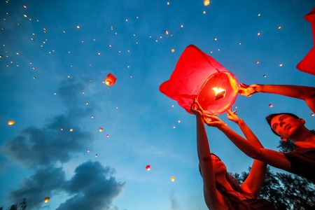 Omsk, Russia - June 16, 2012: festival of Chinese paper lantern, the man starts lantern in the sky at nightのeditorial素材