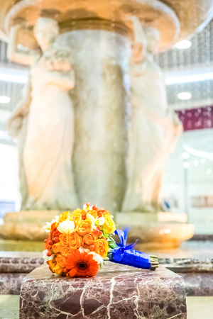 bridal bouquet of orange roses and gerberas with berries  on fountain backgroundの写真素材