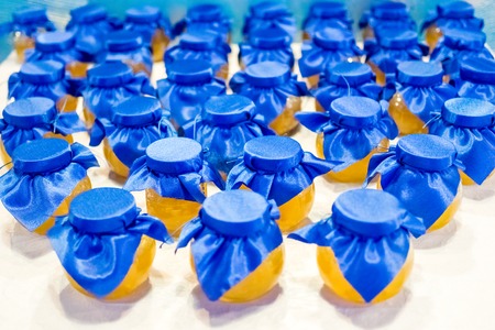 jars with yellow jam covered with blue cloth
